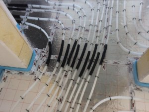 Fußbodenheizung Fugenüberbrückung an den Übergängen zwischen den Räumen. Rohre sind mit Schutz versehen.